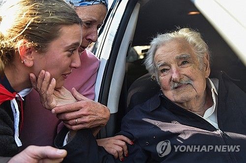 24일(현지시간) 대선 투표 후 주민들의 인사를 받는 우루과이 무히카 전 대통령