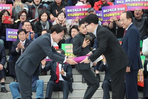 지난 10월 28일 '제천-삼척간 고속도로 예비타당성 통과 및 조기 건설을 위한 대국민 설명회'에서 김진태 강원도지사가 국민의힘 한동훈 대표에게 상소문을 전달하고 있다. 2024.10.28 [연합뉴스 자료사진]