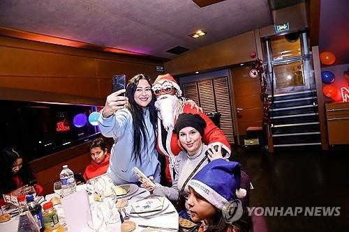 산타 복장을 한 사람과 사진찍는 사람들