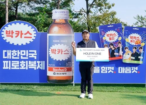 홀인원 상품 앞에서 홀인원 볼을 든 유송규.