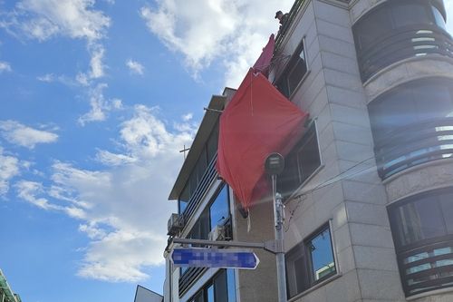 강풍에 떨어지려 하는 건물 옥상에 있던 천막