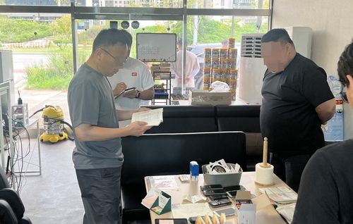 사무실 압수수색 중인 경찰과 운영자 A씨