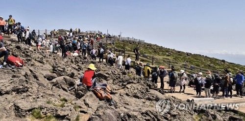 한라산 정상 표지석에서 기념 촬영하려는 등산객들