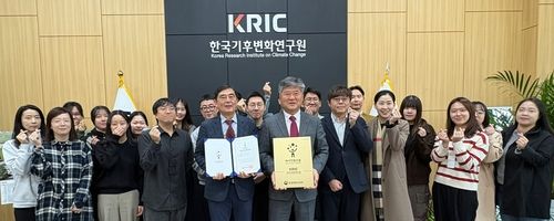 인증 패를 든 김동일 한국기후변화연구원장과 직원들