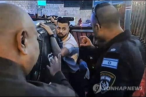 이스라엘 경찰이 사복 차림의 프랑스 군 경찰을 연행하는 모습.