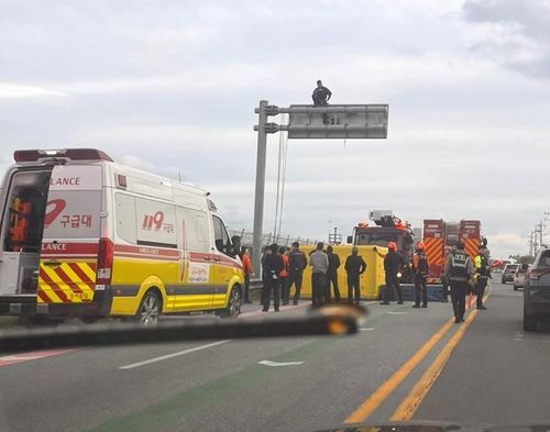 도로표지판 위에서 시위하는 노동자