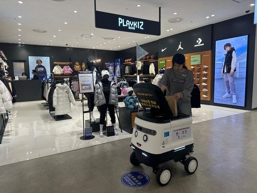 고객에게 보낼 물품을 로봇에 싣고 있는 점원.