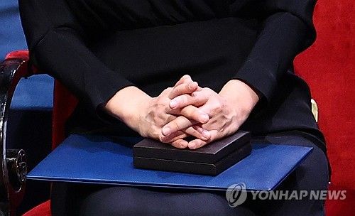 노벨문학상 메달과 증서, 한강 작가 두손에