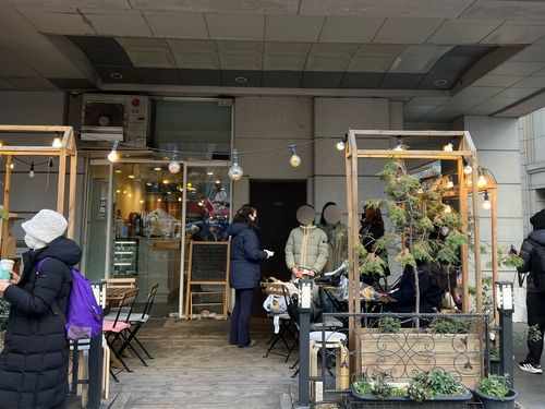 14일 오전 국회의사당 인근 한 카페에서 선결제 음료를 받아 가는 시민들