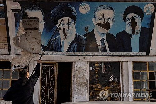 알아사드 정권 붕괴 후 훼손된 '저항의 축' 지도자들의 포스터