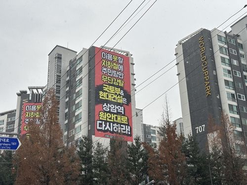 월드컵파크7단지 아파트 외벽에 걸린 대장홍대선 광역철도 노선 반대 현수막