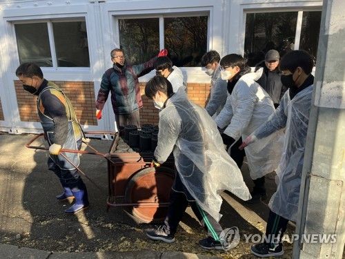 연탄이 가득한 수레를 끄는 자원봉사자들