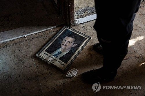 바닥에 떨어진 바샤르 알아사드의 초상