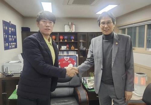 20일 만나 화합 다짐하며 악수하는 김은중 감독과 최순호 단장