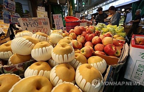 시장에 쌓여 있는 배와 사과
