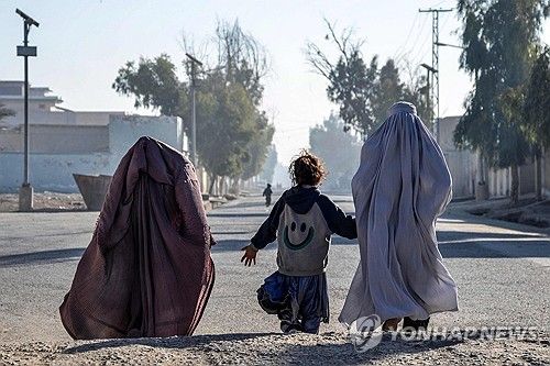 한 소녀와 길을 걷는 아프간 여성들