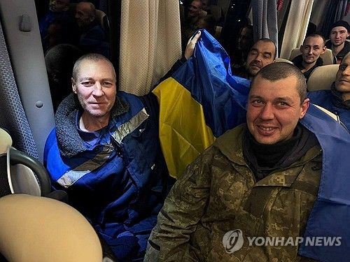 석방된 우크라이나 전쟁 포로가 국기를 두른 모습. 