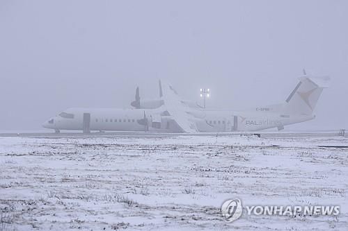 한쪽으로 기울어진 채 멈춰 선 캐나다 PAL항공 여객기