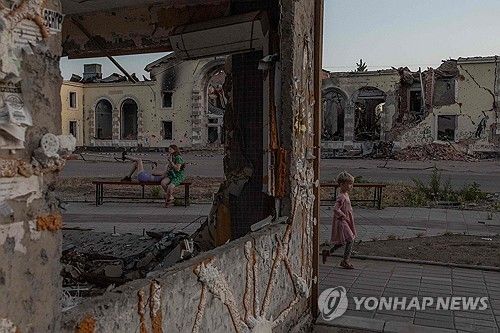 도네츠크 지역의 부서진 건물 잔해 앞 사람들