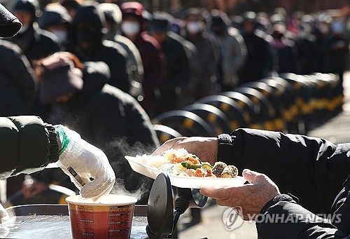 한 해의 마지막 날, 길게 늘어선 무료급식소 줄
