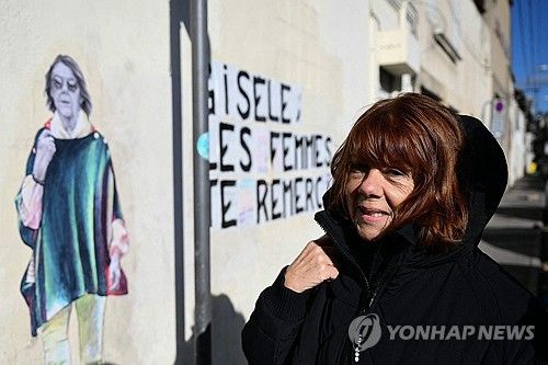 "여성들은 당신에게 고마워요 지젤" 벽화 앞에 선 지젤 펠리코 