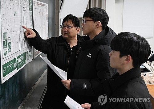 대학 배치표를 확인하는 담임 선생님과 수험생