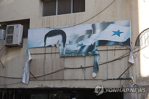 찢긴 바샤르 알아사드 대통령 초상화