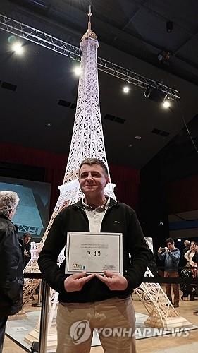 프랑스 모형 제작가 플로 씨가 지난 7일 자신이 성냥개비로 제작한 7.2ｍ 높이의 에펠탑 앞에서 포즈를 취했다. [로이터 연합뉴스 자료사진. 재판매 및 DB 금지] 