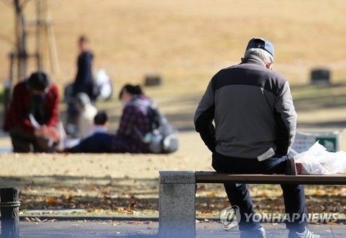도쿄 공원의 벤치에 앉아 있는 고령자