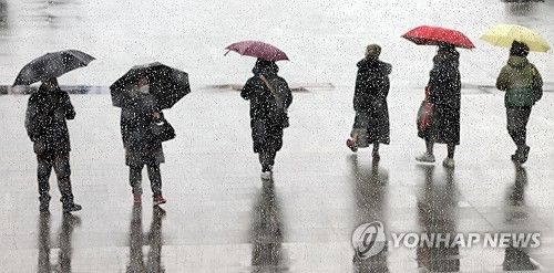 지난 21일 오후 서울 광화문광장을 찾은 시민들이 우산을 쓴 채 걷고 있다. [연합뉴스 자료사진]