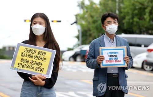 2021년 8월 24일 서울 종로구 감사원 앞에서 열린 산업은행의 대우건설 매각 시도 관련 공익감사 청구 기자회견에서 손팻말을 든 전지예 당시 금융정의연대 사무국장(왼쪽) [연합뉴스 자료사진]