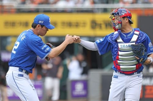 포수 강민호와 주먹을 부딪치는 김재윤