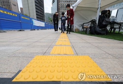 한 어린이가 안대로 눈을 가리고 지팡이를 이용해 점자블록을 걸어보는 이동약자 체험을 하고 있다. 2023.4.30 [연합뉴스 자료사진]