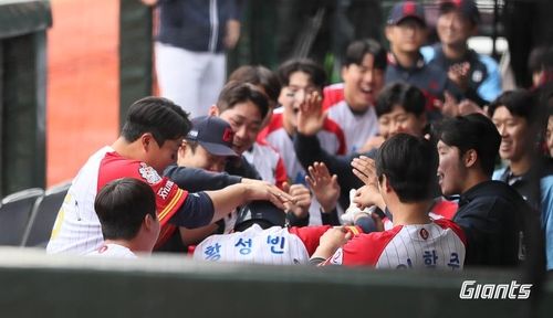 홈런에 동료들로부터 격한 축하를 받는 롯데 황성빈