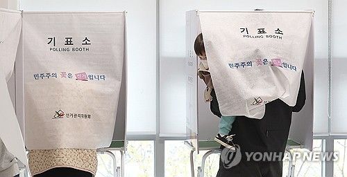 아이와 함께 투표하는 유권자