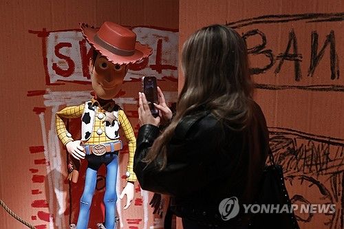 작년 12월 스페인 마드리드의 '픽사 월드 전시회'에서 한 관람객이 '토이 스토리' 캐릭터 모형의 사진을 찍는 모습 