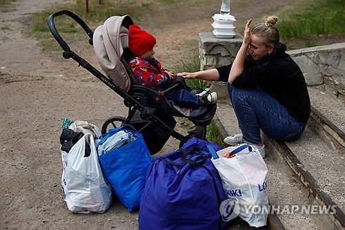 아기와 함께 대피 버스를 기다리며 우는 하르키우 주민