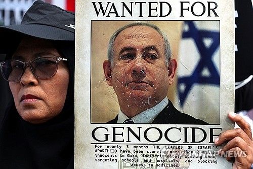 베냐민 네타냐후 이스라엘 총리의 사진을 든 채 반전 시위를 벌이는 인도네시아 활동가