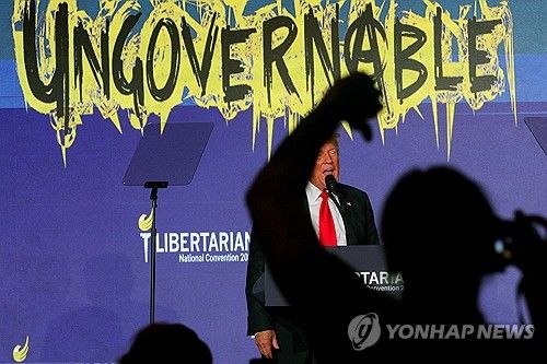 (워싱턴 로이터=연합뉴스) 25일(현지시간) 미국 워싱턴에서 열린 자유당 전당대회에서 공화당 대선 후보인 도널드 트럼프 전 대통령이 연설하는 동안 청중 가운데 한명이 몸짓을 하고 있다. 2024.5.25 photo@yna.co.kr