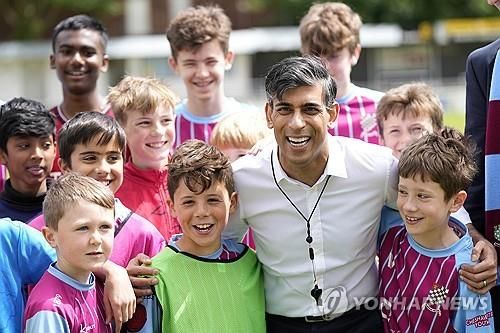 (런던 AP=연합뉴스) 리시 수낵 영국 총리가 27일(현지시간) 런던 북부 체셤 축구 클럽에서 유소년 선수들과 함께 사진을 찍고 있다. 