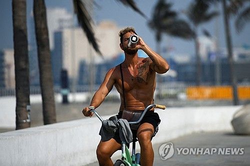 더위 속 음료 마시는 자전거 라이더