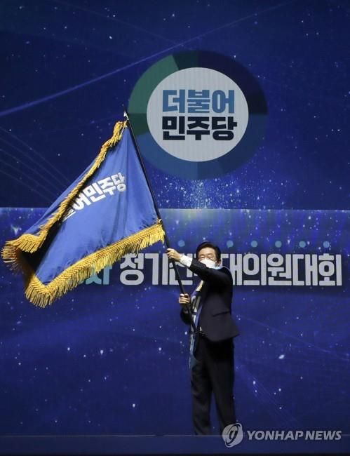 이재명 대표가 2022년 전당대회에서 당기를 흔드는 모습