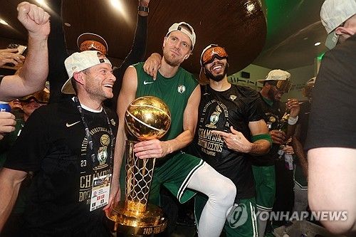 우승 트로피를 든 크리스탑스 포르진기스(가운데)