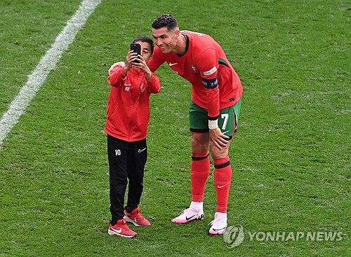 그라운드에 뛰어들어 크리스티아누 호날두와 사진을 찍는 소년 팬