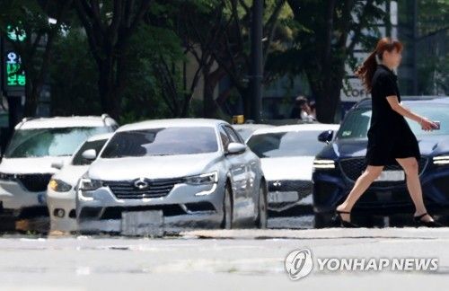 광주 서구 치평동에서 시민이 햇볕에 달궈져 아지랑이가 피어오르는 도로를 걷고 있다. [연합뉴스 자료사진]