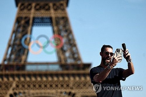 에펠탑을 배경으로 사진 찍는 마이클 펠프스