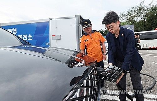 13일 오전 경기 용인시 경부고속도로 부산방향 기흥휴게소에서 김완섭 환경부 장관이 이동형 전기차 충전 서비스 충전 서비스를 살펴보고 있다. [연합뉴스 자료사진]