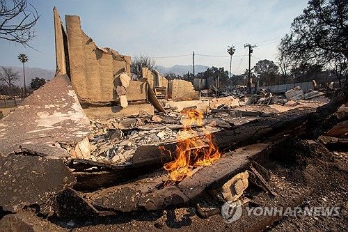 10일(현지시간) LA 이튼 산불 지역에 아직도 불길이 남아있는 모습 