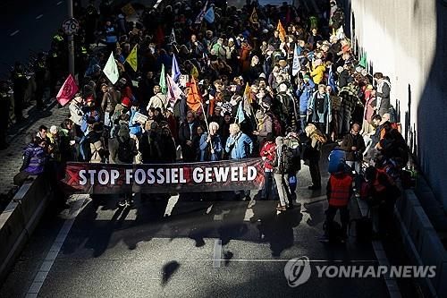 (EPA=연합뉴스) 11일(현지시간) 네덜란드 헤이그에서 기후단체 XR 소속 활동가들이 화석연료 보조금 지급 중단을 요구하는 시위를 하는 모습. 2025.1.11. 