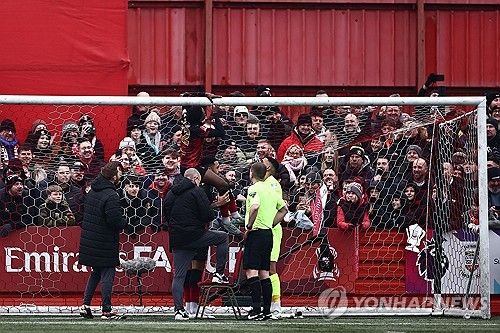 골대 그물을 테이프로 수리하는 탬워스 선수들